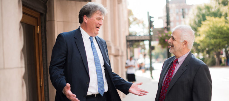 Image of Ed Bleynat and Joe Ferikes in downtown Asheville near the entrance to their offices in the iconic Drhumor Building.